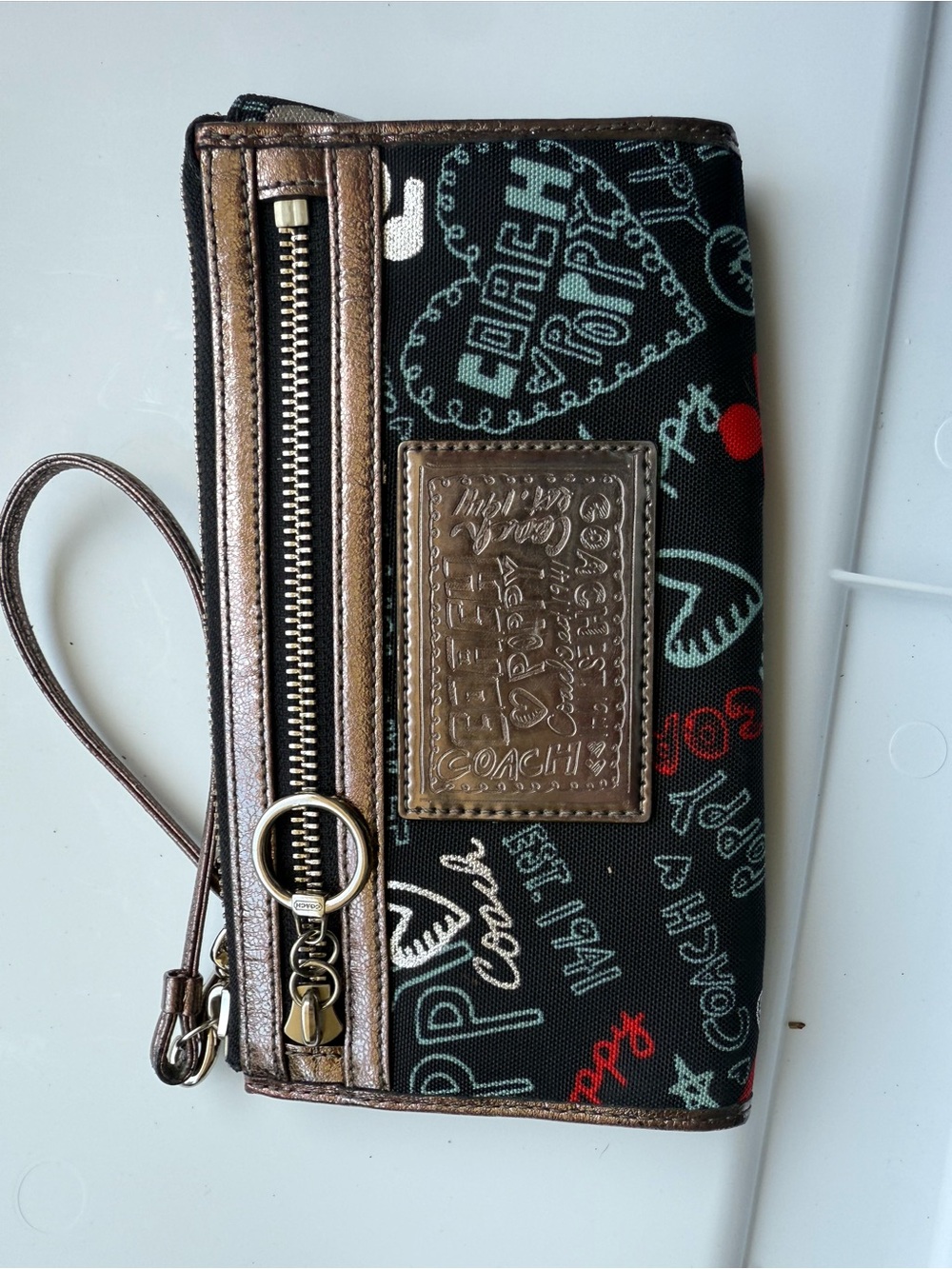 Coach Black Poppy Graffiti Print Wristlet with Bronze Trim and Red Accents